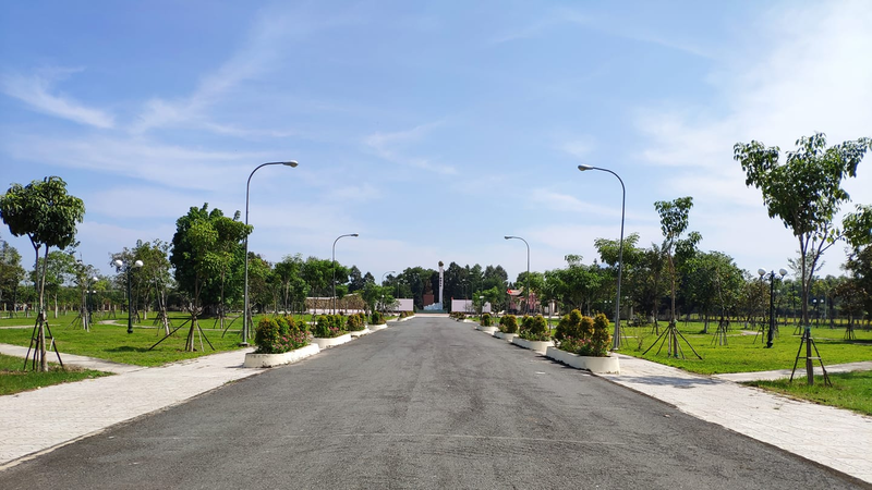 Spacious campus area with green trees on both sides. 