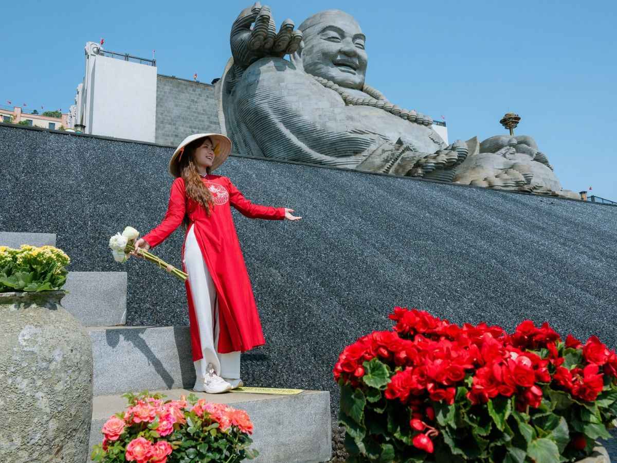 Du khách áo dài check in bên tượng Di Lặc trên đỉnh Núi Bà Đen.