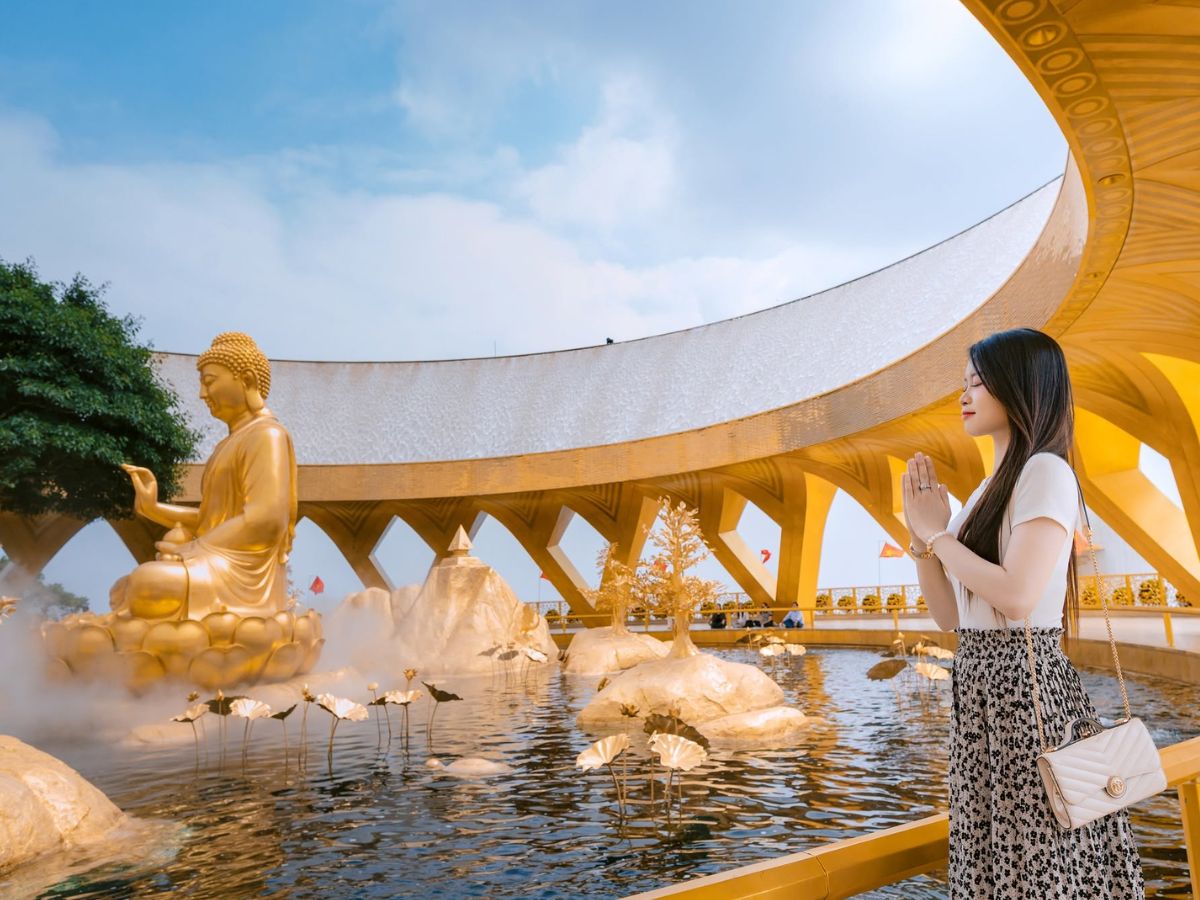 Du khách chiêm bái bên tượng Phật Câu Na Hàm Mâu Ni ở Vườn Ưu Đàm.