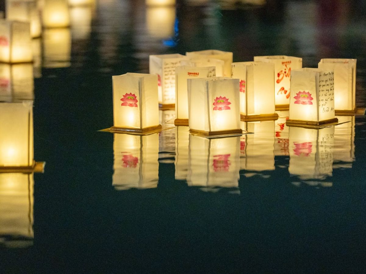 Những ngọn hoa đăng lững lờ trôi trên mặt nước trong đêm lễ hội.