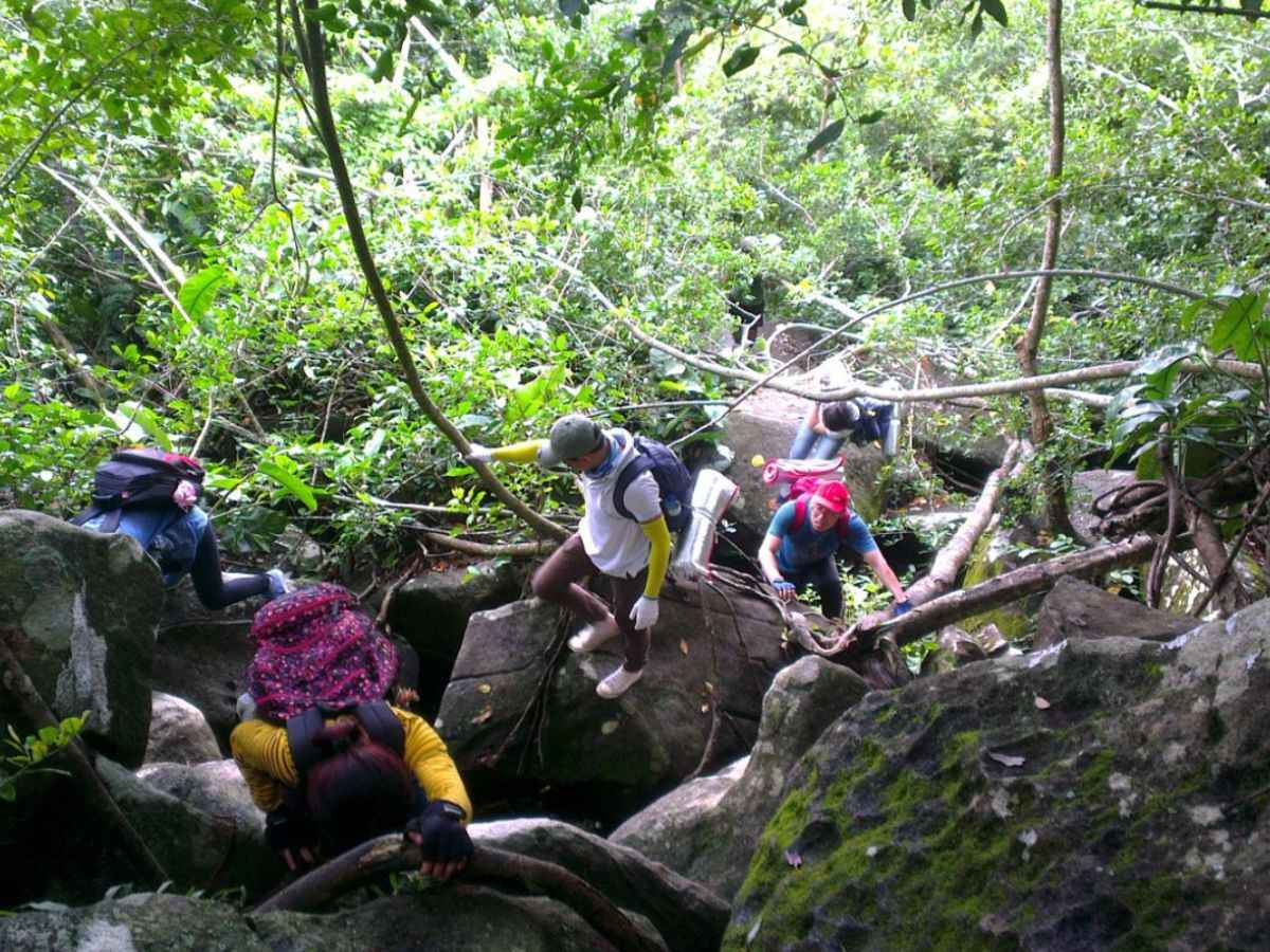 Du khách trekking qua địa hình đá núi để cảm nhận rõ hành trình chinh phục Núi Bà Đen.