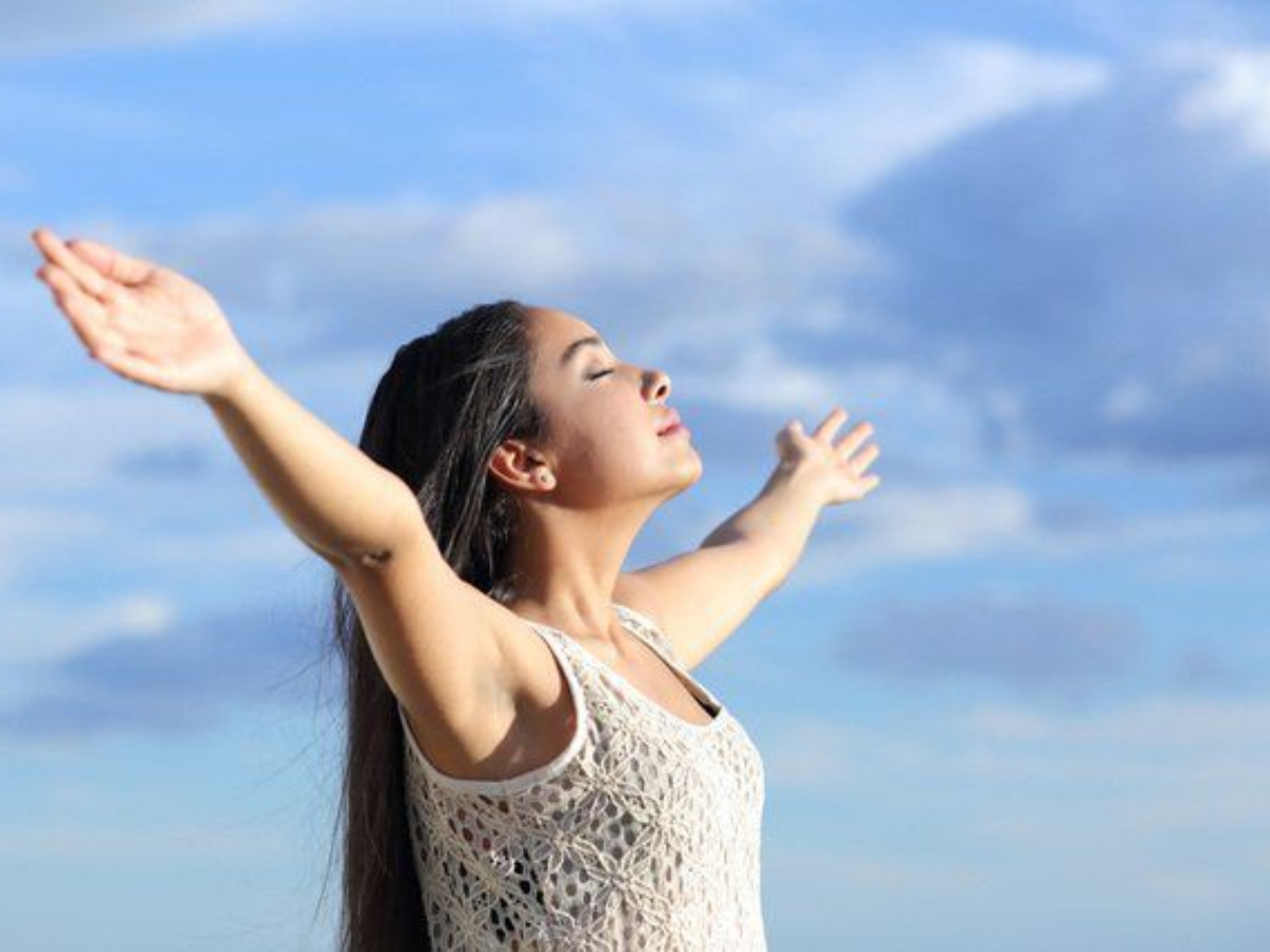 Một người thư giãn vai và hít thở trong không gian thoáng đãng buổi sáng