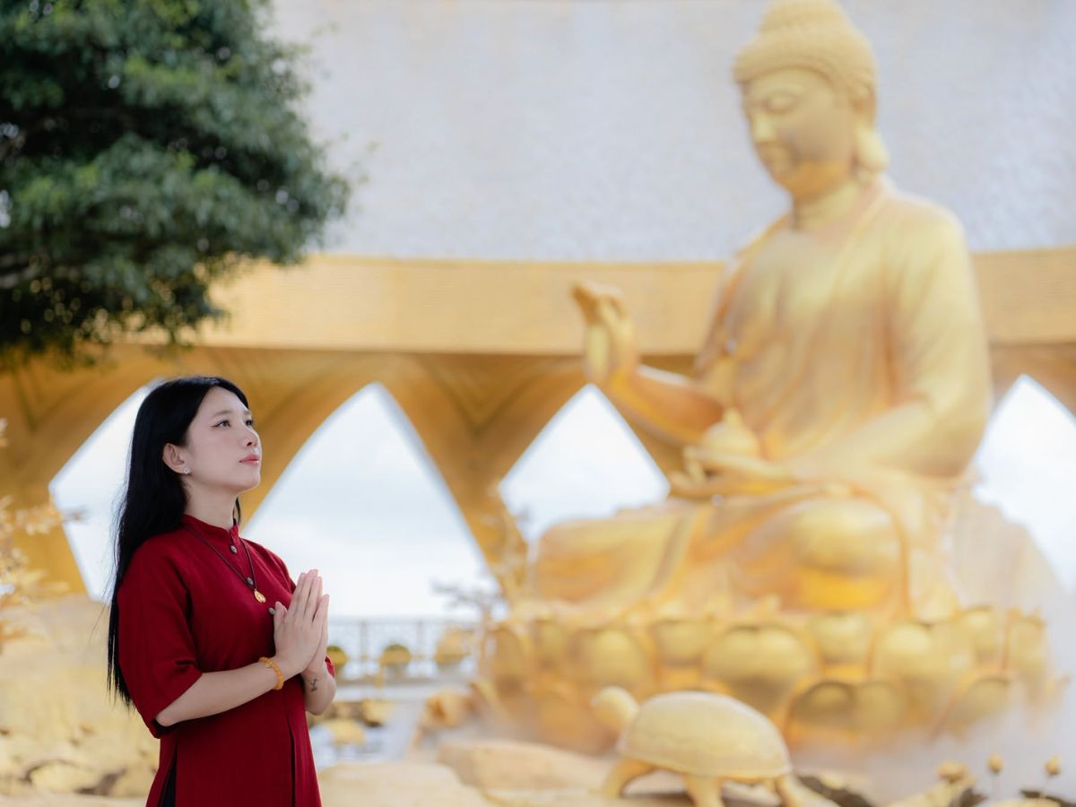 Khoảnh khắc chắp tay bên tượng Phật ở Núi Bà Đen được lưu lại trong ánh sáng dịu. 