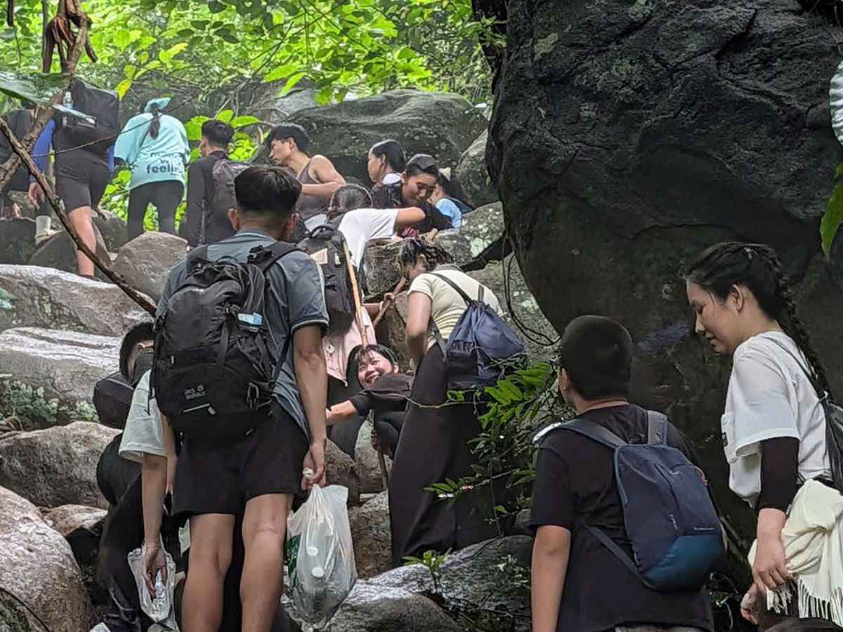 Du khách trekking qua đoạn đá rừng trên tuyến Cột Điện Núi Bà Đen.